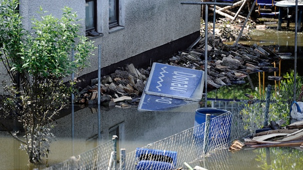 Ein angeschwemmtes Straßenschild mit der Aufschrift "Donau" liegt am 08.06.2013 im Deggendorfer Ortsteil Fischerdorf im Hochwasser der Donau. | Bild: picture-alliance/dpa