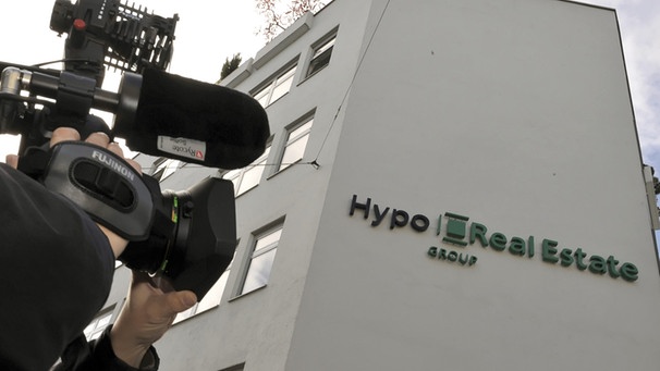 Ein Kameramann steht am 06.10.2008 vor der damaligen Zentrale der Hypo Real Estate (HRE) in München (Bayern).  | Bild: dpa-Bildfunk