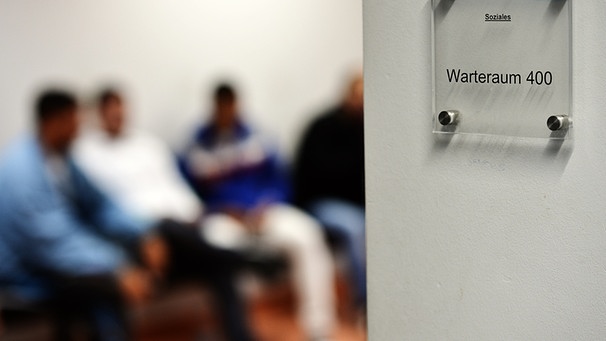 Symbolbild: Wartende Flüchtlinge im Warteraum einer Behörde | Bild: picture-alliance/dpa