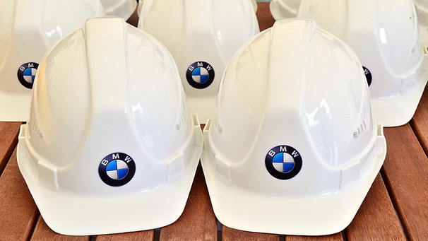 Symbolbild: Mehrere Bauhelme mit BMW-Logo auf einem Tisch | Bild: picture-alliance/dpa/Martin Schutt