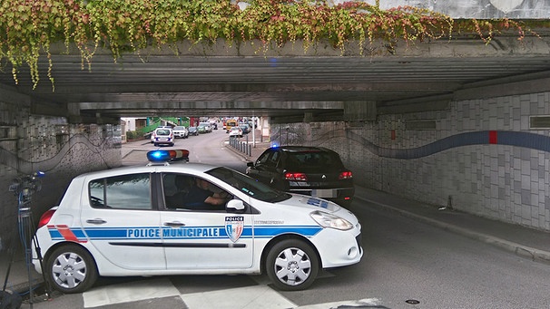 Ein Polizeiauto blockiert nach der Geiselnahme in der Normandie eine Straßenunterführung | Bild: dpa-Bildfunk