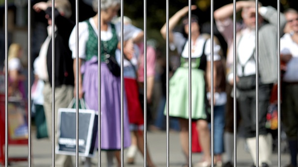 ARCHIV: Wiesnbesucher stehen am Montag (28.09.2009) hinter einem Zaun auf dem Oktoberfest in München (Oberbayern). Wegen der jüngsten Terrordrohungen wurden die Straßen rund um das Oktoberfest abgeriegelt.  | Bild: picture-alliance/dpa/Lukas Barth