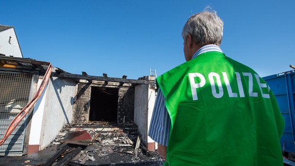 Ein Spurenermittler der Polizei steht in Reichertshofen im Ortsteil Winden vor einer geplanten Unterkunft für Asylbewerber, die durch Brandstiftung beschädigt wurde. | Bild: Bayerischer Rundfunk