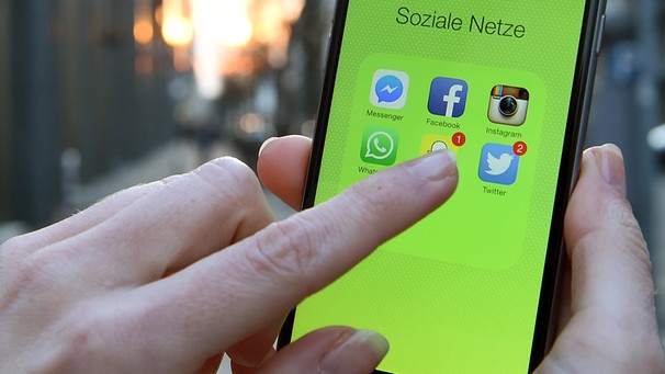 Hand tippt auf Smartphone mit Icons von Sozialen Netzwerken auf dem Display | Bild: picture-alliance/dpa