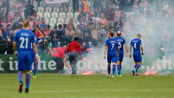 Ordungskräfte entfernen Fackeln vom Spielfeld während des Spiels Tschechien gegen Kroatien | Bild: Reuters (RNSP)