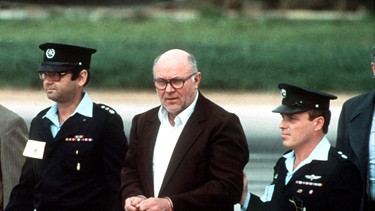 1986: John Demjanjuk (Mitte) bei seiner Auslieferung nach Israel | Bild: picture-alliance/dpa