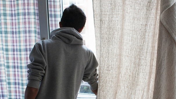 Junger Mann am Fenster (Symbolbild) | Bild: picture-alliance/dpa