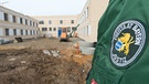 Ein Justizvollzugsbeamte steht am 20.03.2013 auf der Baustelle des Neubaus für Sicherungsverwahrte auf dem Gelände der Justizvollzugsanstalt (JVA) in Straubing. | Bild: picture-alliance/dpa