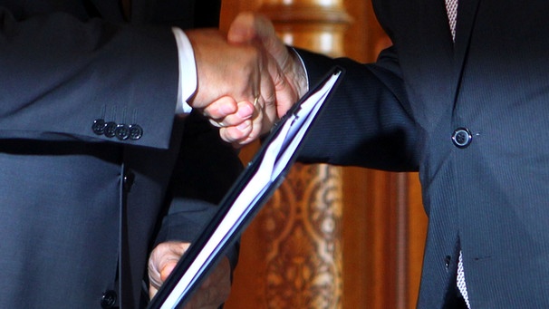 Handshake bei Aktenübergabe | Bild: picture-alliance/dpa