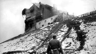 Kriegsende 1945: US-Soldat steht vor Hitlers "Führerhauptquartier", dem in Brand gesetzten Berghof, auf dem Obersalzberg | Bild: picture-alliance/dpa