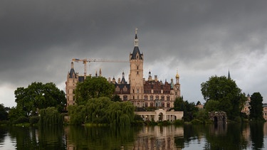 Dunkle Wolken hängen über dem Schweriner Schloss | Bild: pa/dpa/Daniel Bockwoldt