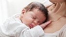 Neugeborenes liegt auf der Brust einer Frau | Bild: colourbox.com