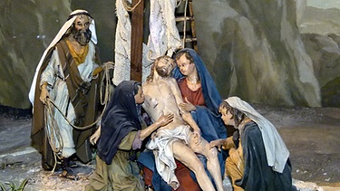 Holzfiguren einer Passionskrippe zeigen Jesus, der vom Kreuz genommen wurde und von seiner Mutter und weiteren Frauen beweint wird | Bild: Marion Krüger-Hundrup