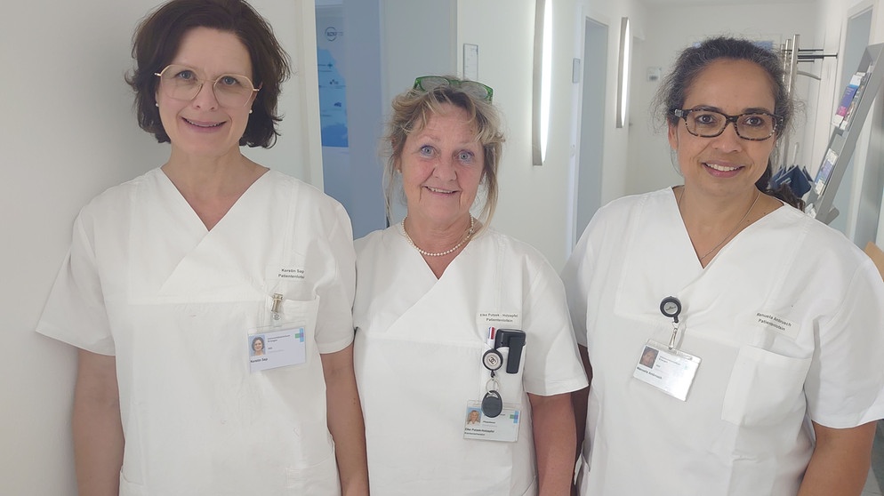 Drei Frauen im weißen Kittel stehen in dem Gang eines Krankenhauses. | Bild: BR24/Ulrike Nikola