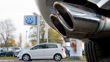 Auspuff eines Diesel-Autos vor einem Volkswagen-Logo (Symbolbild) | Bild: picture-alliance/dpa