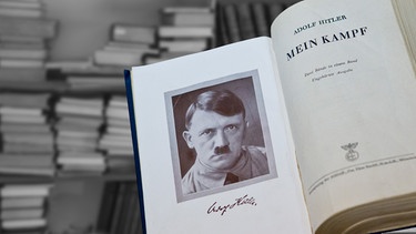 Bildmontage: Aufgeschlagene Seite im Buch "Mein Kampf" mit einer Abbildung von Adolf Hitler darin, dahinter ein Bücherregal | Bild: picture-alliance/dpa, colourbox, montage: BR