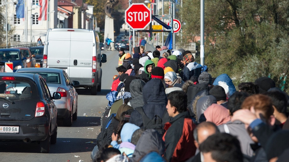 Flüchtlinge warten am 31.10.2015 bei Simbach am Inn (Bayern) an der österreichisch-deutschen Grenze auf der Innbrücke. | Bild: dpa-Bildfunk