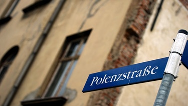 Das Straßenschild "Polenzstraße" in Zwickau vor einer Wand eines verfallenen Hauses zu sehen | Bild: picture-alliance/dpa