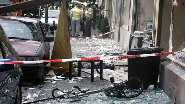 Ein Polizist sichert in Köln die Spuren einer Explosion in der Keupstraße (Archivfoto vom 09.06.2004). | Bild: picture-alliance/dpa