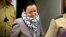 Die Angeklagte Beate Zschäpe betritt am 15.10.2013 den Gerichtssaal in München. Die Neonazi-Gruppe NSU soll zwischen 2000 und 2007 zehn Morde begangen haben.  | Bild: picture-alliance/dpa