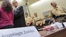 Die Angeklagte Beate Zschäpe steht  im Gerichtssaal und unterhält sich mit ihren Anwälten | Bild: picture-alliance/dpa