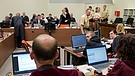 Die Angeklagten und ihre Anwälte (im Hintergrund) sitzen am 19.05.2014 im Gerichtssaal des Oberlandesgerichts in München (Bayern) vor dem Tisch mit der Bundesstaatsanwaltschaft (im Vordergrund mit roten Roben) | Bild: picture-alliance/dpa