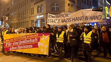 Demonstranten gehen in München auf der Dachauer Straße und tragen Transparente mit der Aufschrift: "Für eine Gesellschaft ohne Rassismus" und "NSU-Terror: Staat und Nazis Hand in Hand". Die Initiative "Keupstraße ist überall" hat zu der Demonstration aufgerufen, um sich gegen Rassismus und Fremdenfeindlichkeit zu stellen und auf eine lückenlose Aufklärung der Morde und Anschläge des NSU zu dringen  | Bild: picture-alliance/dpa
