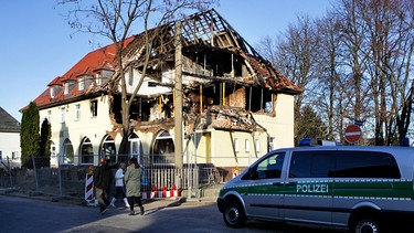 Polizisten sichern das durch eine Explosion zerstörte Haus in der Frühlingsstraße in Zwickau.  | Bild: picture-alliance/dpa
