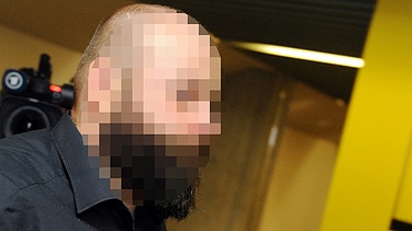 Der Zeuge Andre K., mit Vollbart und kurz geschorenen Haaren, geht am 05.02.2014 in den Gerichtssaal des Oberlandesgerichts in München | Bild: picture-alliance/dpa