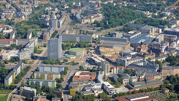 Das Stadtzentrum von Chemnitz in Westsachsen mit dem Hotel Mercure (M. l.) und der benachbarten Stadthalle (daneben r.), sowie dem neu gestalteten Stadtkern rund um das historische Rathaus (M. r.) | Bild: picture-alliance/dpa