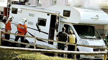Feuerwehrleute und Polizisten standen am 04.11.2011 in Eisenach vor einem qualmenden Wohnwagen, in dem zwei Leichen der Neonazi-Terrorzelle (NSU) gefunden wurden. | Bild: picture-alliance/dpa