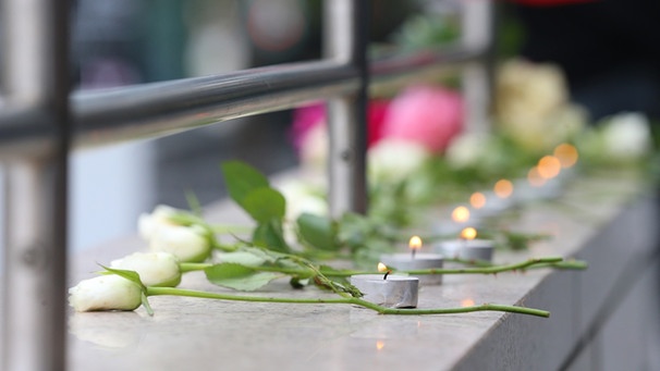 Blumen und Kerzen erinnern am Olympia-Einkaufszentrum in München an die neun Opfer des Amoklaufs. | Bild: picture-alliance/dpa/Karl-Josef Hildenbrand