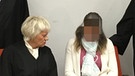 Prozess um Messerstecherei auf der Wiesn: Die Angeklagte sitzt zwischen ihren Anwälten. | Bild: Julia Binder / BR