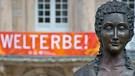 Eine Büste der Markgräfin Wilhelmine von Bayreuth steht vor dem Markgräflichen Opernhaus in Bayreuth (Oberfranken), an dessen Balkon am 16.07.2012 ein Banner mit der Aufschrift "Welterbe!" hängt. Die Unesco hat das Opernhaus am 30.06.2012 als Weltkulturerbe anerkannt. | Bild: picture-alliance/dpa