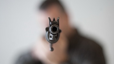 Mann hält eine Schusswaffe in den Händen  | Bild: picture-alliance/dpa/Victoria Bonn-Meuser