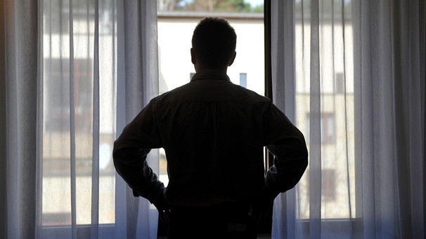 Mann steht am Fenster | Bild: picture-alliance/dpa