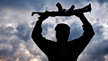 Symbolbild: Islamischer Kämpfer hält Maschinengewehr über den Kopf | Bild: colourbox.com; Montage: BR