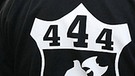 Ein Mann mit dem Zahlencode 444 ("Deutschland den Deutschen") auf dem Kapuzenpullover an einer Neonazi-Demo in Berlin teil. | Bild: picture-alliance/dpa; Montage: BR