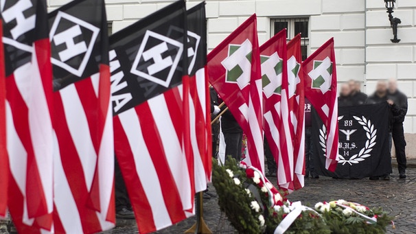 Kraenze mit Flaggen der 'Hungaristischen Bewegung' und der 'Ungarischen Nationalen Front' MNA. Im Hintergrund Kerle mit der magischen Zahl '88', die fuer 'Heil Hitler' steht. | Bild: picture-alliance/dpa