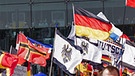 Teilnehmer der Demonstration "Merkel muss weg" schwenken ihre Deutschlandfahnen | Bild: picture-alliance/dpa