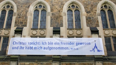 Plakat zum Thema Asyl an der Friedenskirche in Radebeul Altkoetzschenbroda bei Dresden  | Bild: picture-alliance/dpa/Rainer Oettel