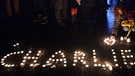 Der Name "Charlie" in Großbuchstauben aus brennenden Teelichtern am Boden | Bild: picture-alliance/dpa
