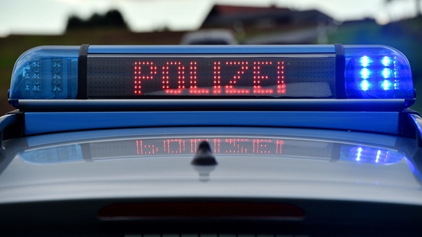 Symbolbild: Rote Lichtaufschrift Polizei bei einem Polizeiwagen.  | Bild: pa/dpa/Frank May