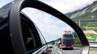 Lastwagen im Außenspiegel eines Pkw; Symbolbild Lkw-Transitverkehr auf der Inntalautobahn | Bild: picture-alliance/dpa/EXPA/ J. Groder