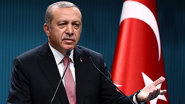 Erdogan vor einer türkischen Flagge bei einer Pressekonferenz | Bild: picture-alliance/dpa