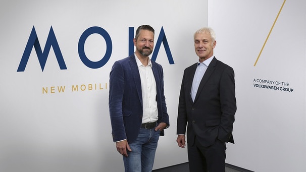 Matthias Müller (r), den Vorstandsvorsitzenden der Volkswagen AG, zusammen mit dem VW-Manager Ole Harms, der die neue Mobilitätsmarke Moia leiten soll.  | Bild: pa/dpa/Matthias Leitzke