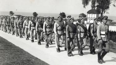 Männer in Uniformen des Freiwilligen Arbeitsdienstes (FAD) Griebenow marschieren im September 1933 mit einem Marschlied über die Strandpromenade des Ostseebades Göhren auf der Insel Rügen. | Bild: picture-alliance/dpa