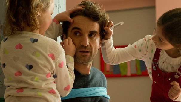 Filmszene aus "Das Leben ist kein Kindergarten - Umzugschaos". Hauptdarstelle Oliver Wnuk wird von seinen beiden Film-Kindern mit Stiften im Gesicht angemalt. | Bild: ARD Degeto, Volker Roloff
