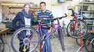 Checker Tobi (links) mit Adnan Albashi in der Fahrradwerkstatt der Flüchtlingsunterkunft Bayernkaserne in München.  | Bild: BR/megaherz