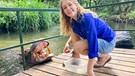 Nina füttert ein Flusspferd mit Süßkartoffeln - der Lieblingssnack von Hippo Jessica. | Bild: BR/Text und Bild Medienproduktion GmbH & Co.KG/Ben Wolter 